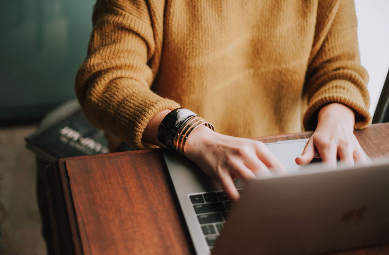 Person typing on a laptop as they sit at a desk.