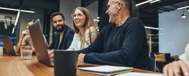 People in an office sitting at table to discuss talent acquisition