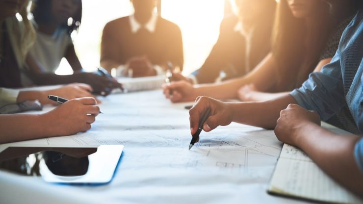 people collaborating about recruiting tools on a big table