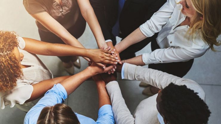 Group of people in a circle with hands together