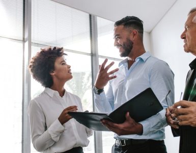 Three people in an office talking about Talent Attraction