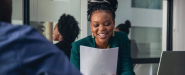 internal candidate being asked a question in a job interview looking at a piece of paper