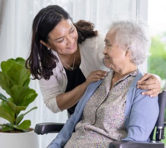 younger woman caregiving for a senior woman in a wheelchair