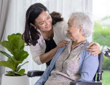 younger woman caregiving for a senior woman in a wheelchair